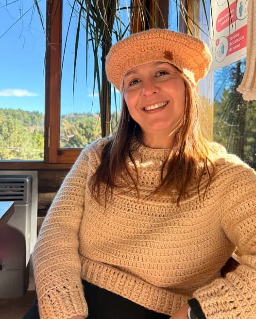 Fer, creadora de Felisa, sonriendo con boina y suéter tejidos.